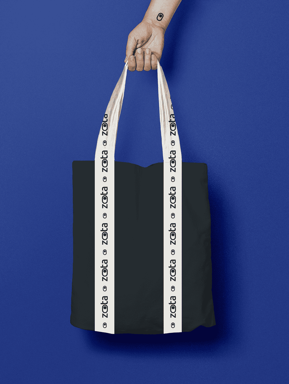 תיק שחור עם רצועות מודפסות "ZOTA" על רקע כחול.
